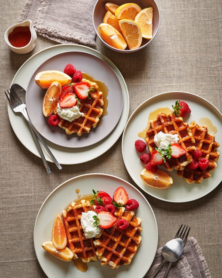 overhead perspective of a table with plates of waffles and fruit as an example of a brand food photography client photoshoot