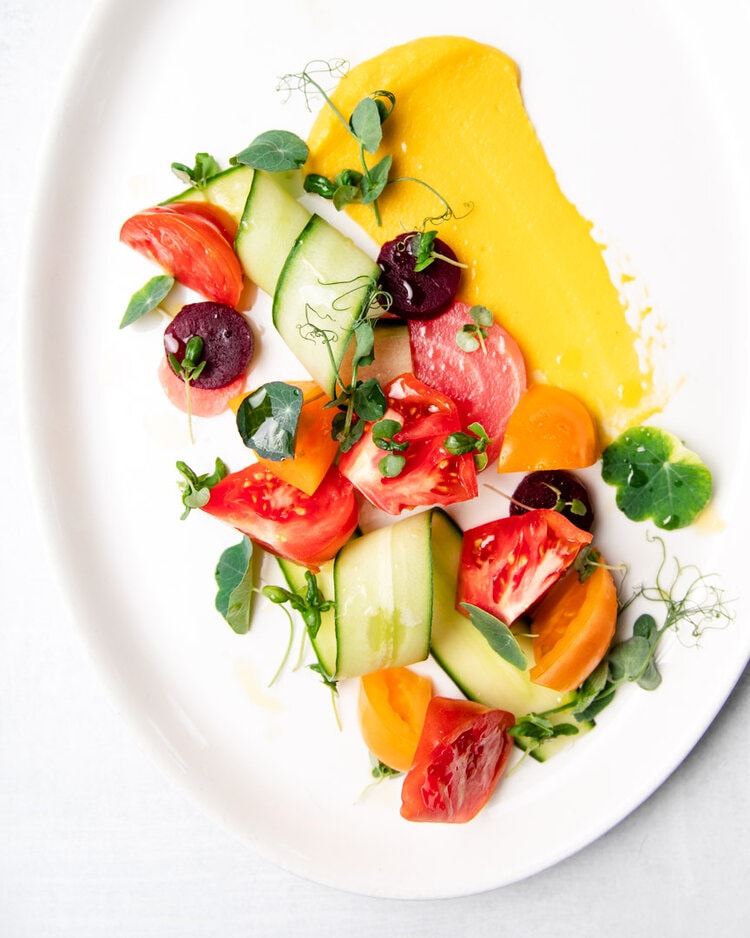 Heirloom Tomato Salad captured in a restaurant dining room with flash