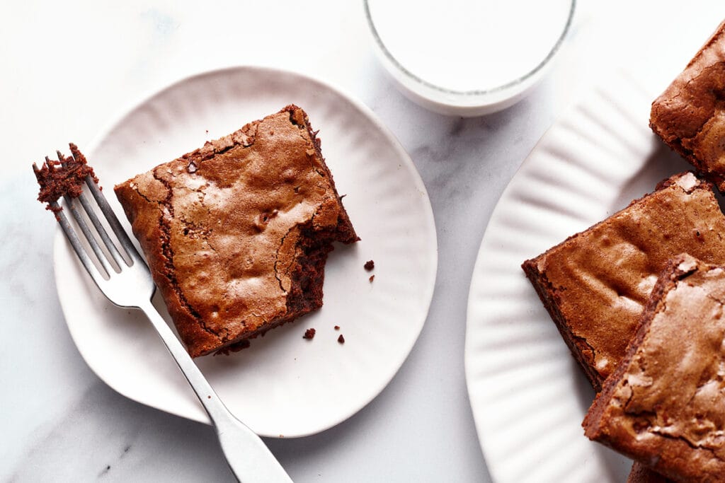 brownies on white plates with milk as an example of a photograph captured for a food blogger food photography client