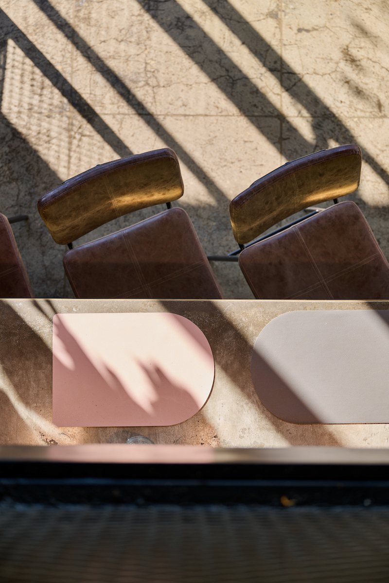 Light and shadow across leather chairs and a table