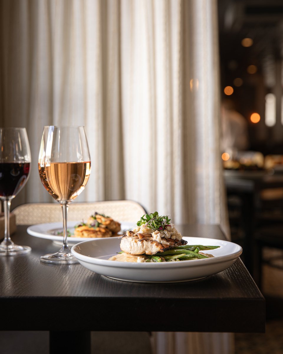 Moody restaurant interior with grilled dish and wine