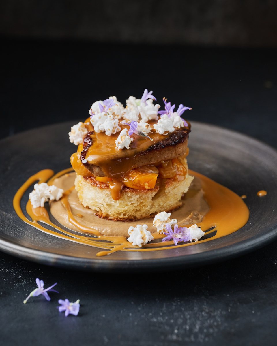 Seared dish on brioche with caramel, popcorn and edible flowers
