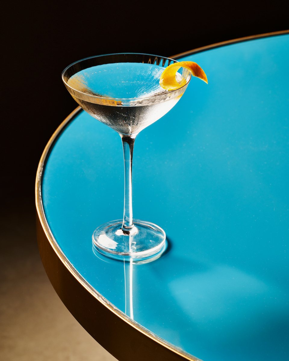 Martini with citrus twist on a blue table